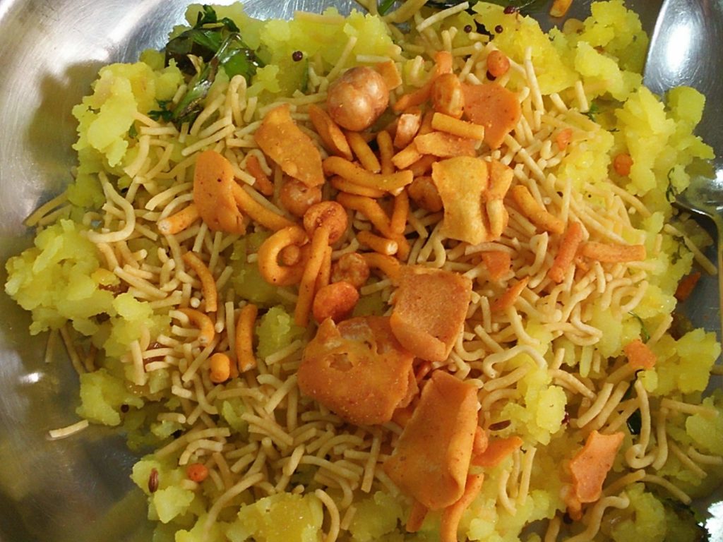Poha served hot and garnished with sev and farsan