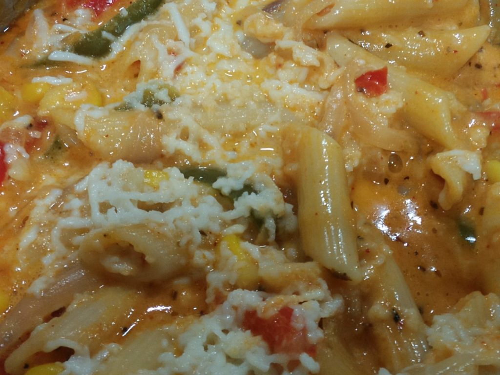 Pink Pasta topped with cheese. One of the popular dishes in India. An Indian Fusion recipe for pink pasta