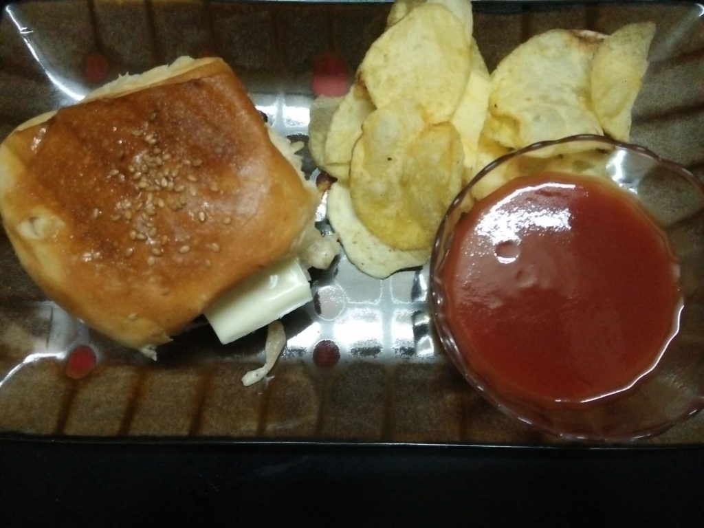 Vegetarian Burger served with potato chips and tomato ketchup. An Indian fusion recipe for burger