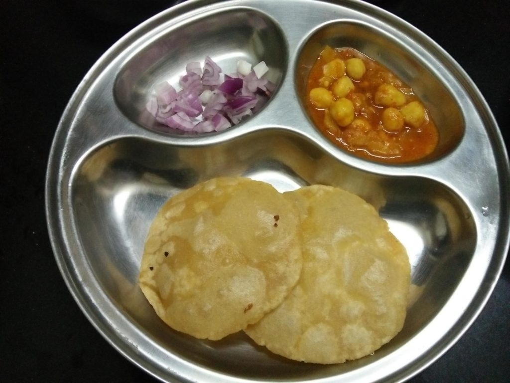 Chole puri served with some raw onions