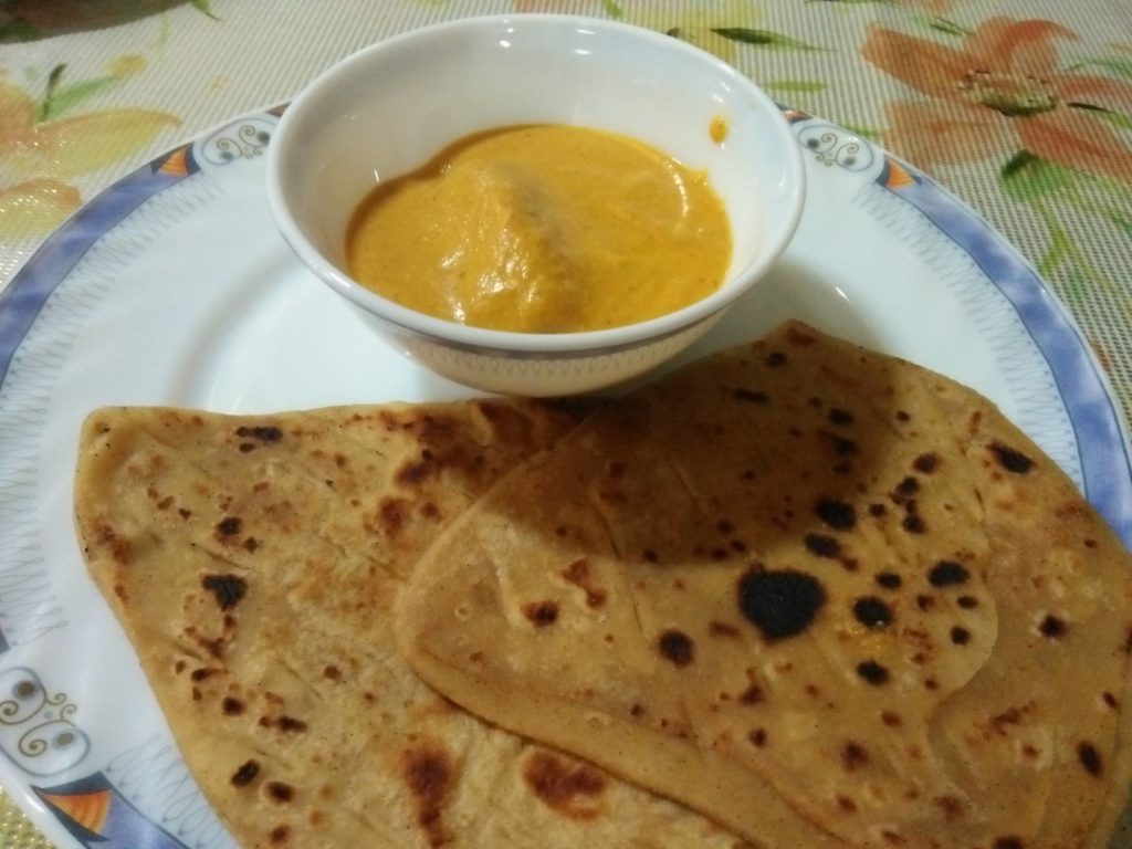 Malai Kofta served with plain wheat Parathas.