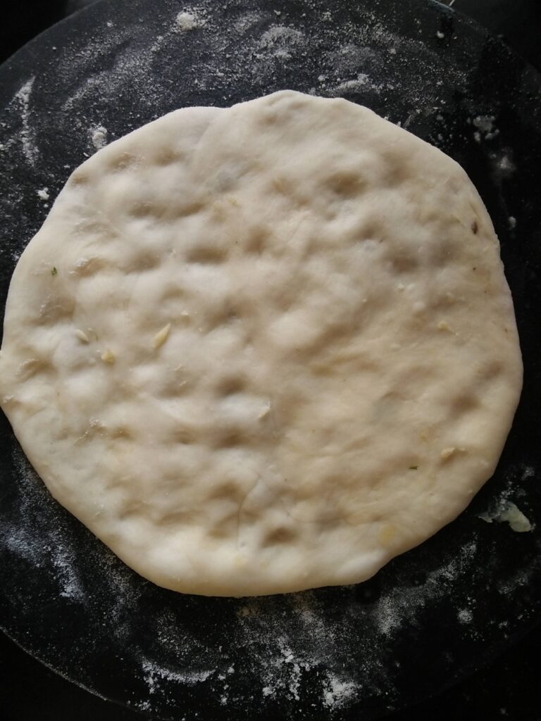 Amritsari Kulcha rolled and pressed gently with fingers to prepare for cooking.