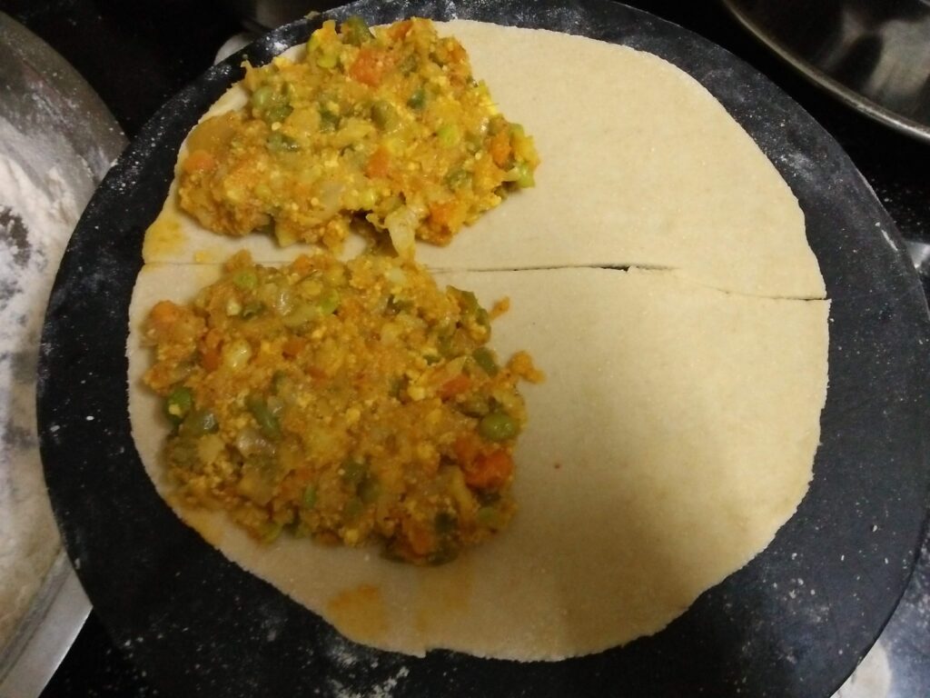 Mixed Veg Paratha stuffing placed on one side of the rolled Paratha