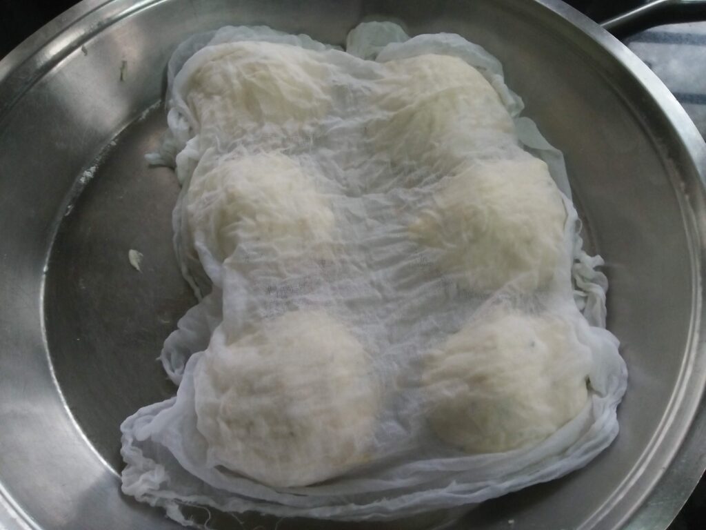The kulcha Dough Balls covered with a damp muslin cloth