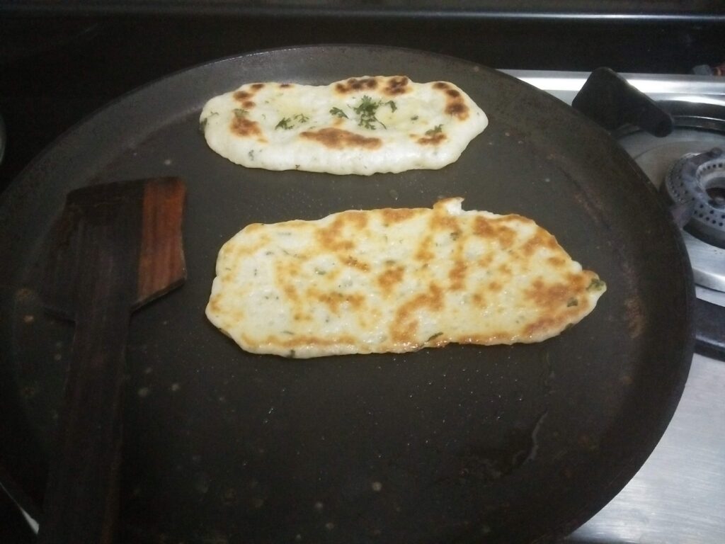 Kulcha Bread cooked on both sides with ladle and ghee applied on both sides.